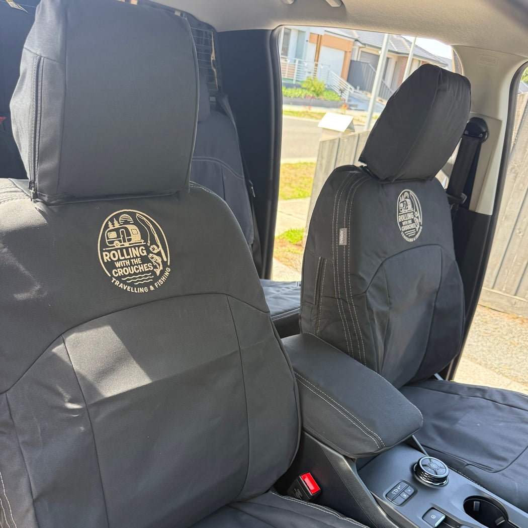 Razorback 4x4 gray car seat covers installed on the front seats of a vehicle, featuring circular embroidered logos for 'Rolling Crockery'.